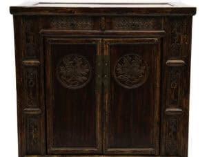 Close-up front view of the floral motifs including peonies , symbol of prosperity on the 19th century cabinet at Humble House gallery.