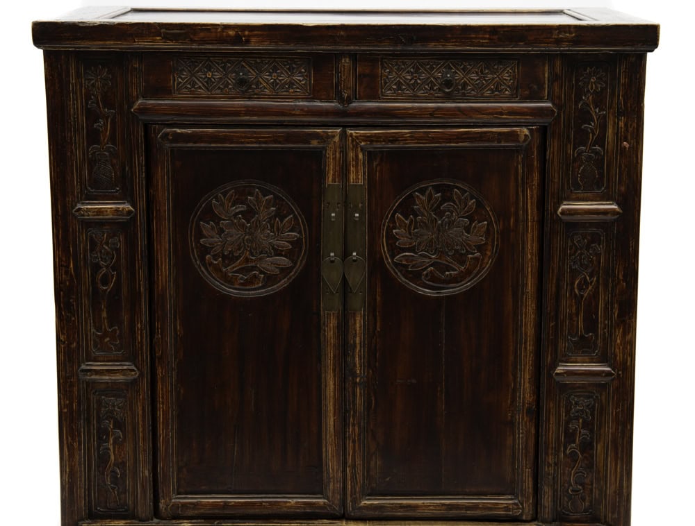 Close-up front view of the floral motifs including peonies , symbol of prosperity on the 19th century cabinet at Humble House gallery.