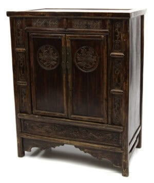Angled view of the 19th century Chinese cabinet with peony medallion carvings and intricate detailing.