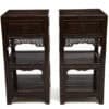 Front view of a pair of 19th century Chinese elmwood tea stands with carved apron and open shelves.